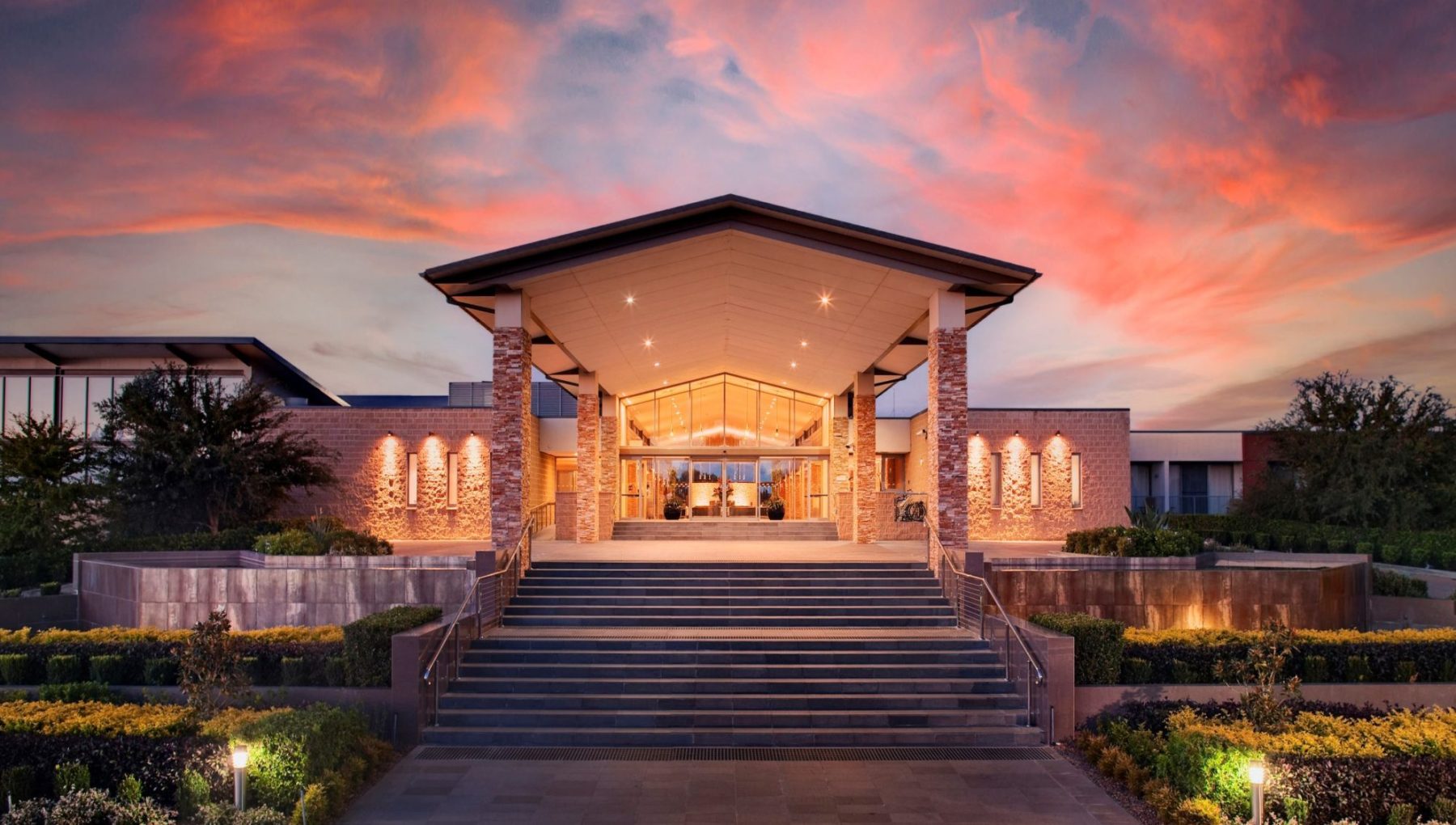 Sunset illuminating the main entrance of a picturesque resort.