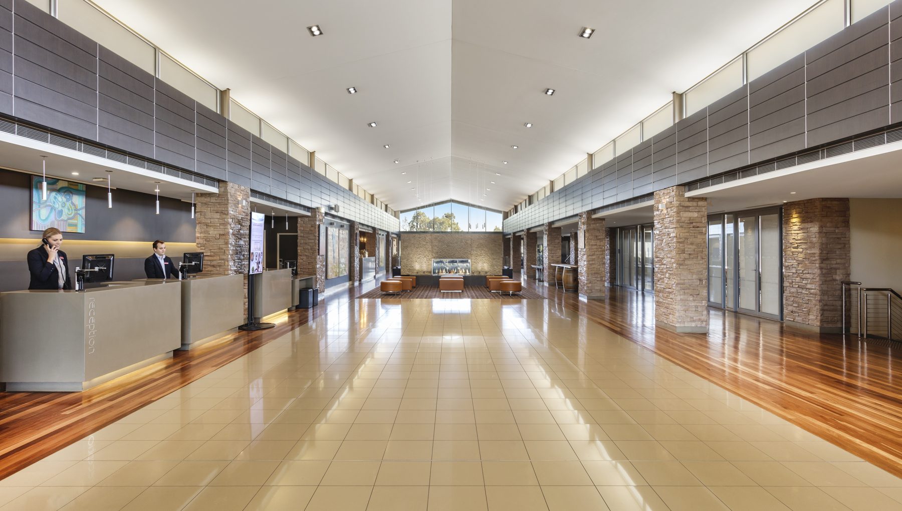 View of the well-lit lobby with attentive staff at reception desks, offering clear and welcoming walkways for guests.